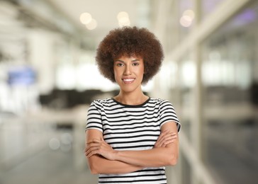 Portrait of happy woman in office. Beautiful girl looking at camera and smiling on blurred background
