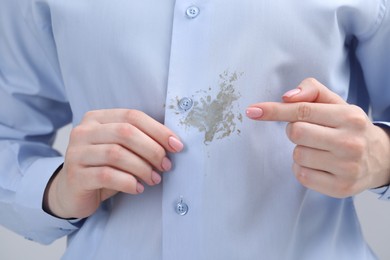 Woman showing stain on her shirt, closeup