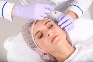 Photo of Woman undergoing face biorevitalization procedure in salon. Cosmetic treatment