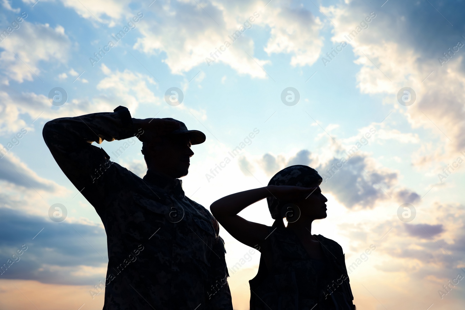 Photo of Soldiers in uniform saluting outdoors. Military service