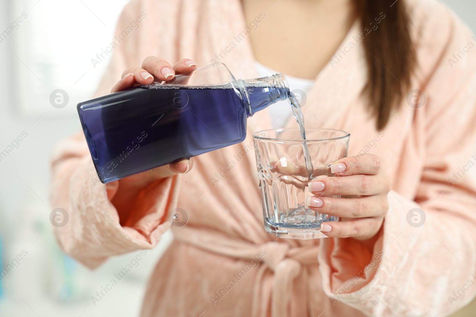 Photo of Young woman using mouthwash on light background, closeup