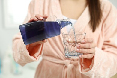 Photo of Young woman using mouthwash on light background, closeup