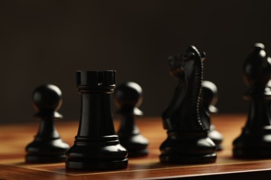 Photo of Chessboard with game pieces on dark background, closeup