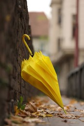 Photo of Autumn atmosphere. One yellow umbrella on city street