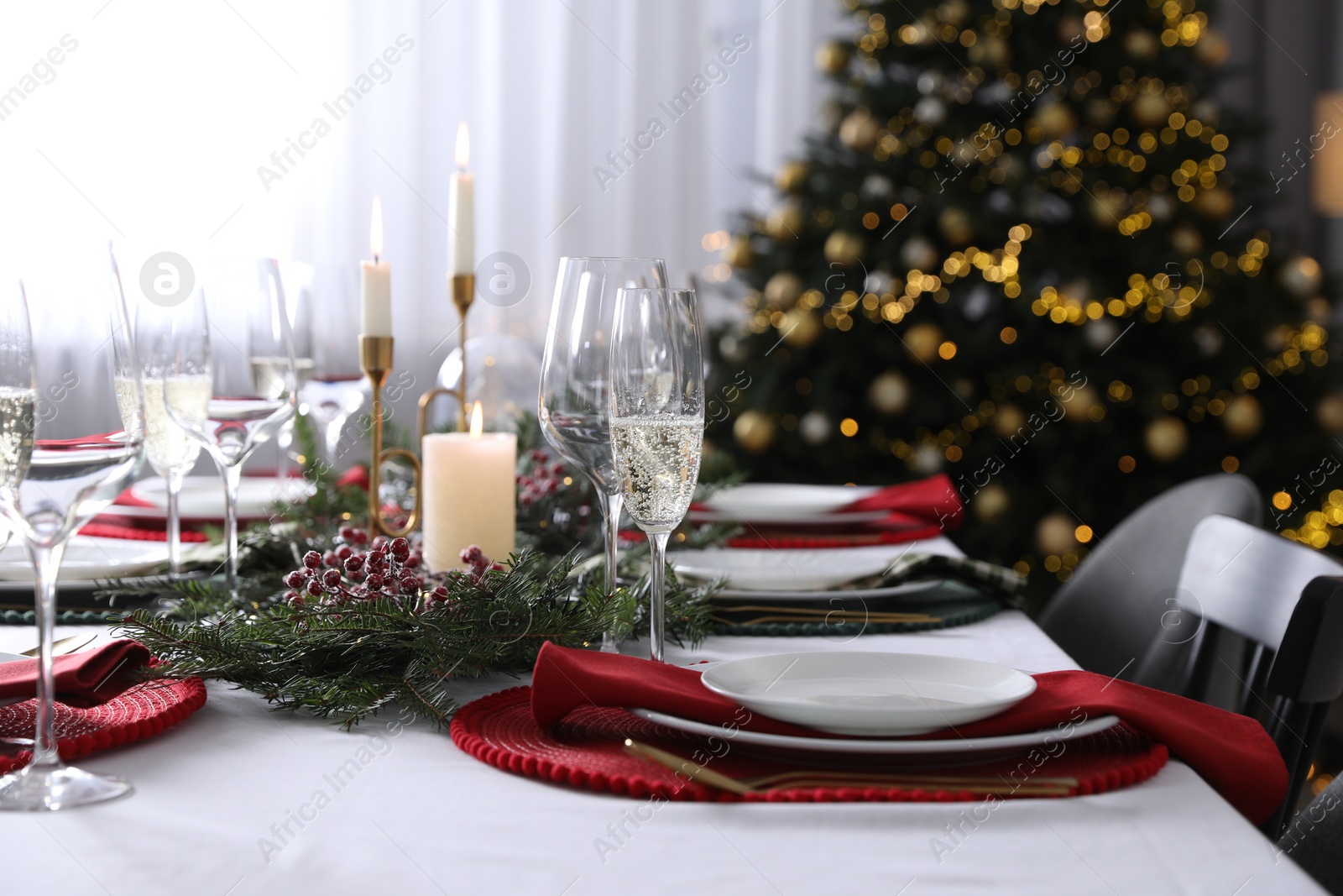 Photo of Christmas table setting with festive decor and dishware indoors