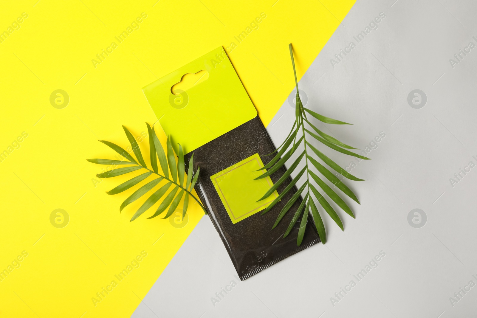 Photo of Scented sachet and green leaves on color background, flat lay