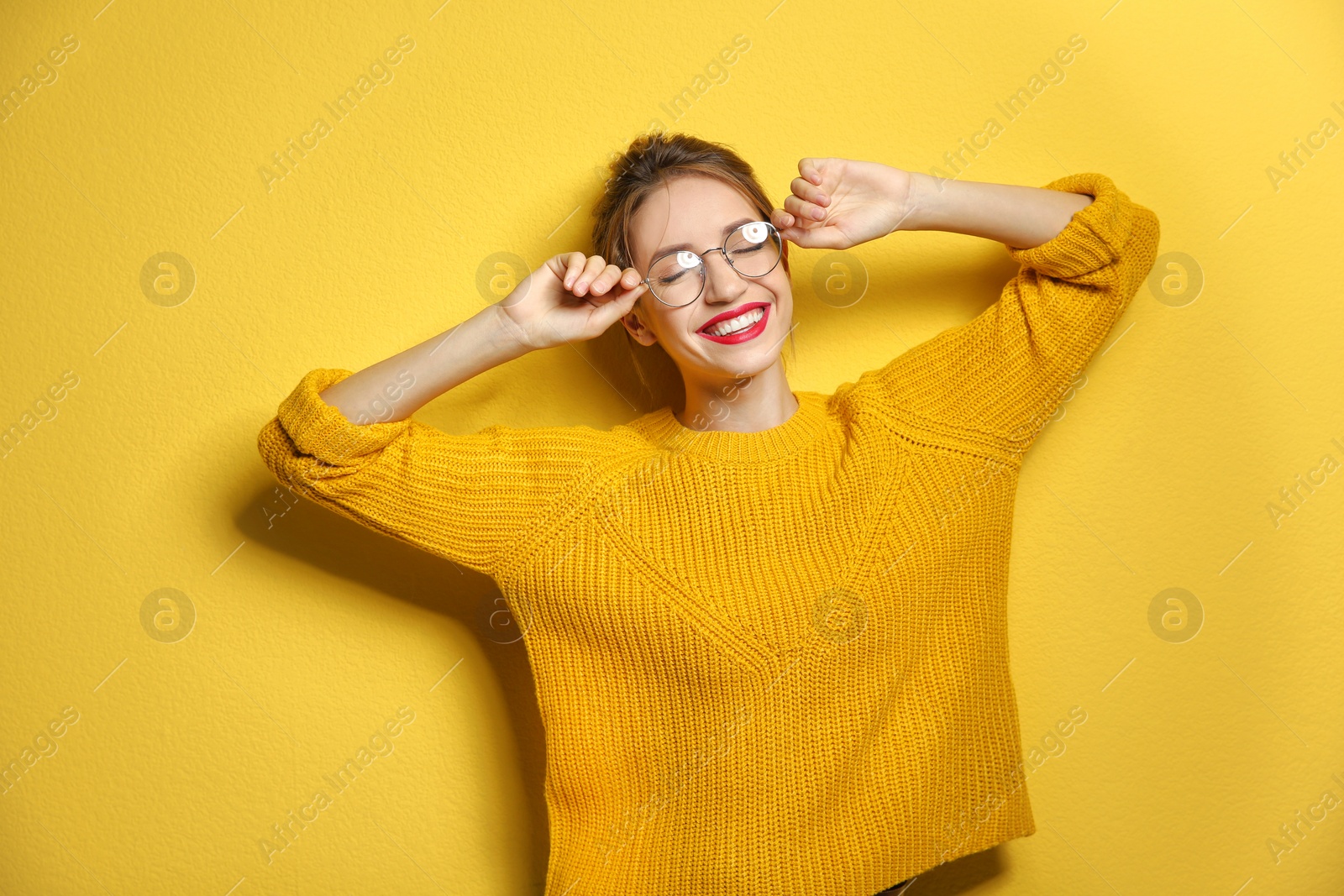 Photo of Beautiful young woman in warm sweater on color background