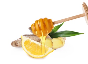 Image of Honey dripping from dipper, cut lemon and ginger root on white background