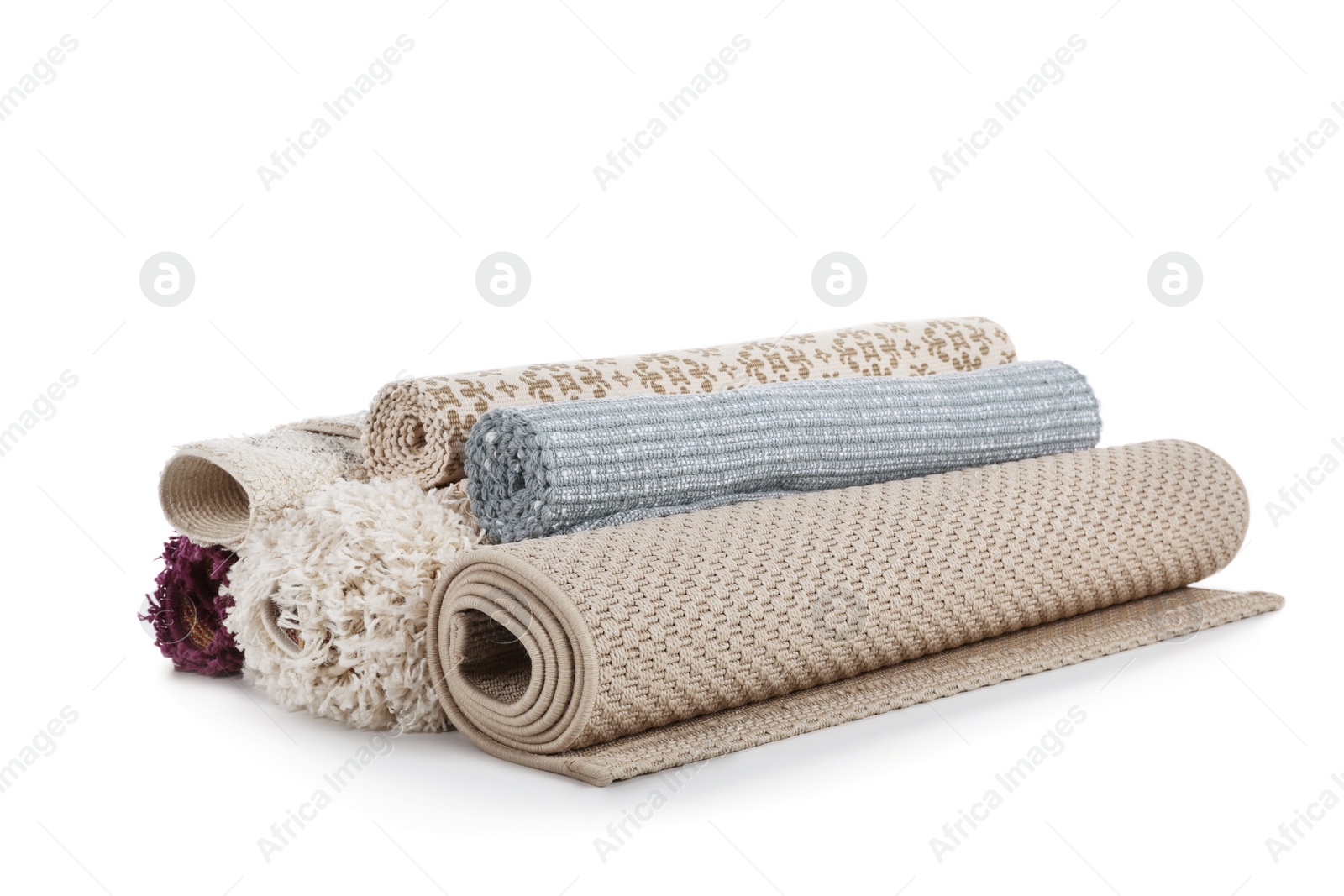 Photo of Different rolled carpets on white background. Interior element