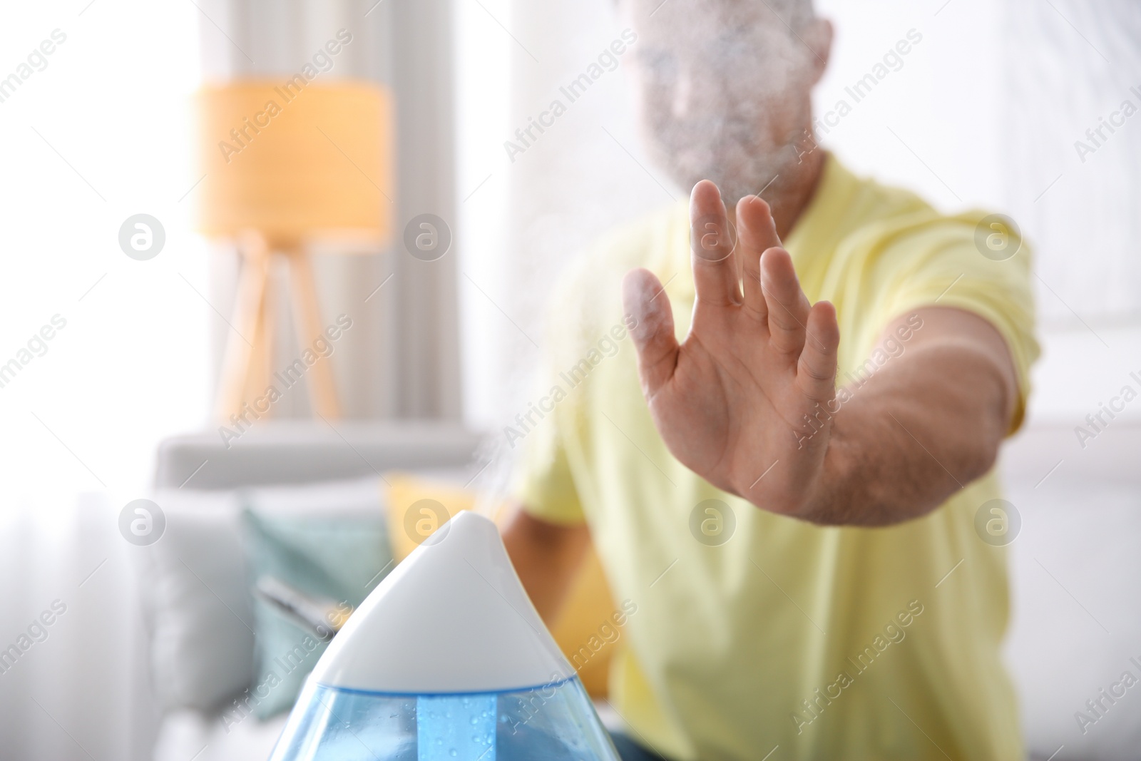 Photo of Man near modern air humidifier at home, closeup