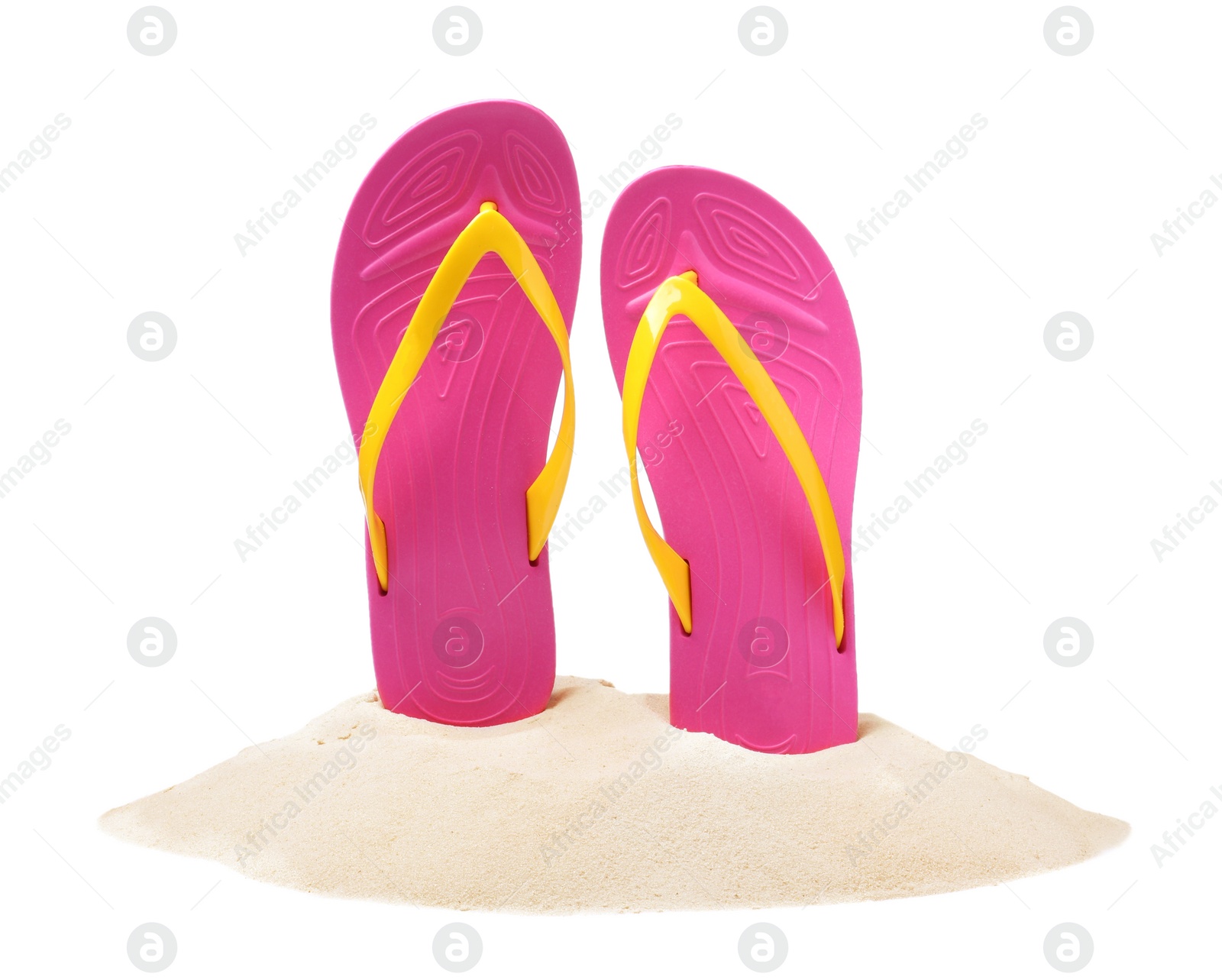 Photo of Pink flip flops in sand on white background