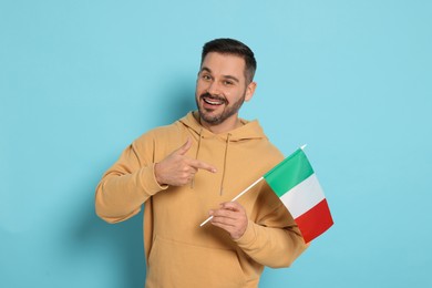 Photo of Man with flag of Italy on light blue background