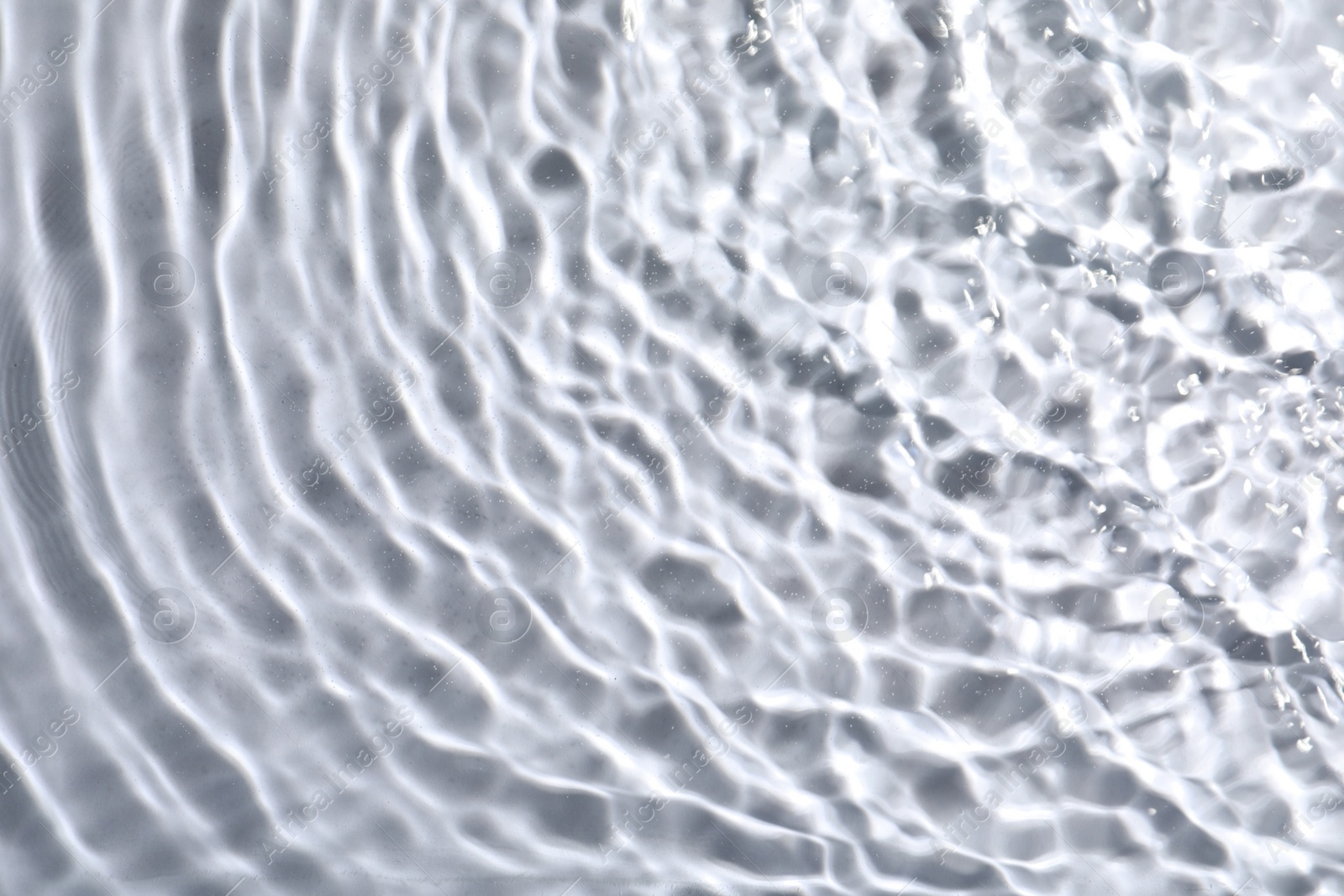 Photo of Closeup view of water with rippled surface on light background