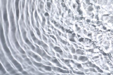 Photo of Closeup view of water with rippled surface on light background