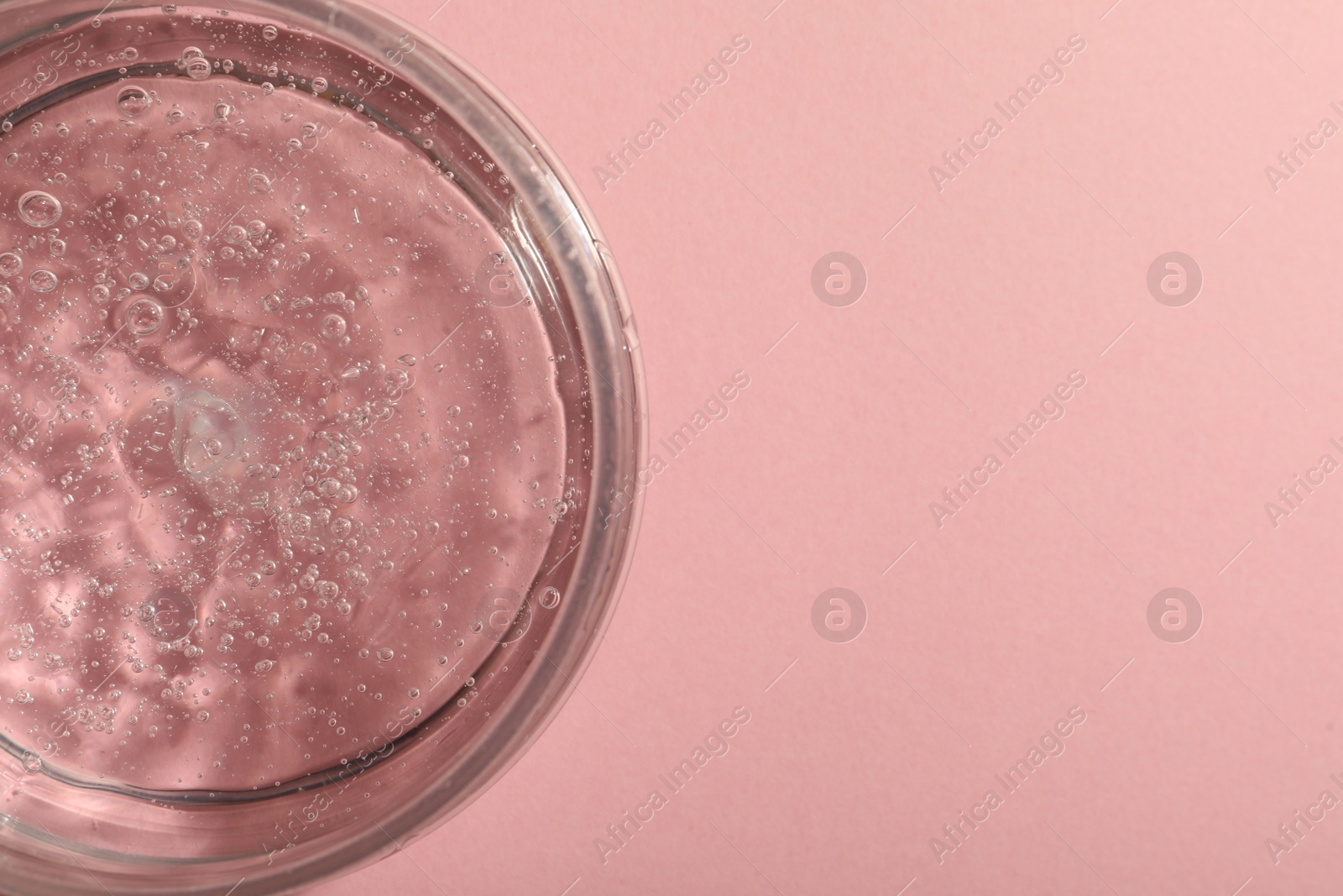 Photo of Jar of cosmetic gel on pink background, top view. Space for text