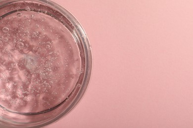 Photo of Jar of cosmetic gel on pink background, top view. Space for text