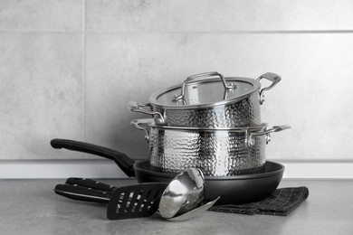 Set of different cooking utensils on grey countertop in kitchen