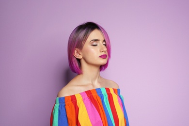 Photo of Young woman with trendy hairstyle against color background