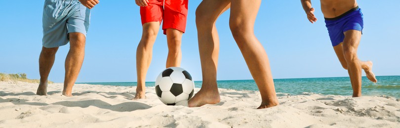 Image of Group of friends playing football on sandy beach, closeup. Banner design