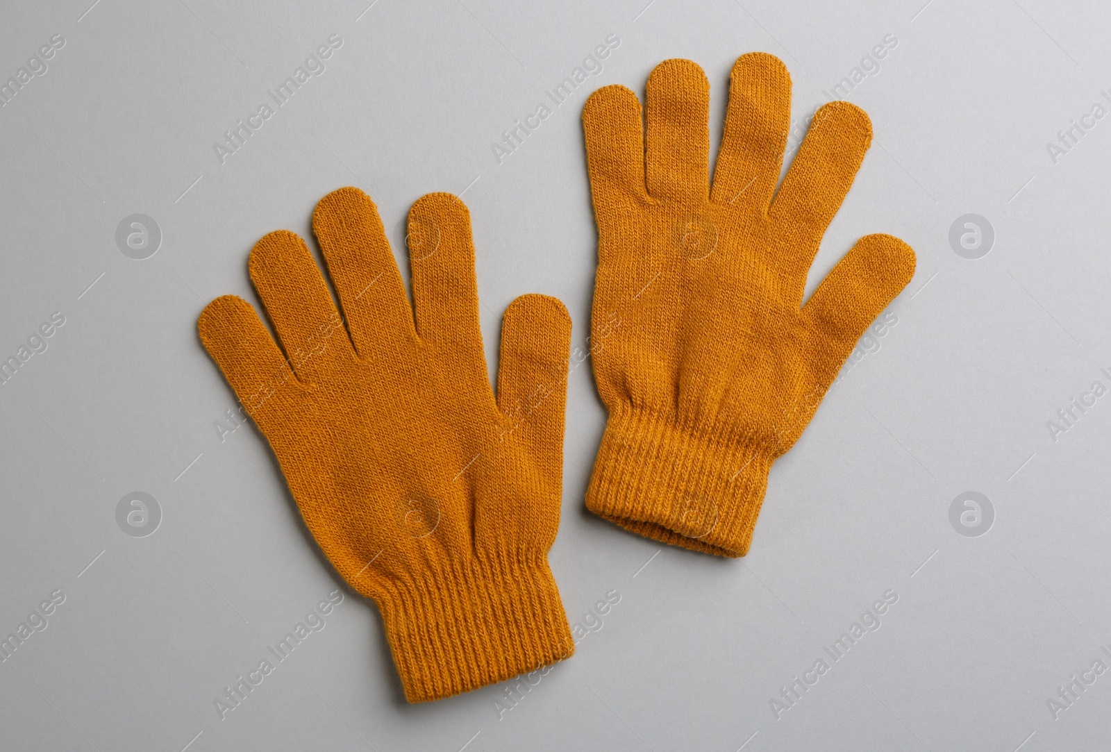 Photo of Pair of stylish woolen gloves on light grey background, flat lay