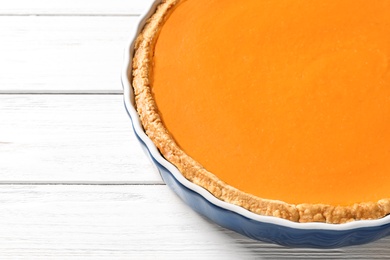 Photo of Fresh delicious homemade pumpkin pie and space for text on wooden background