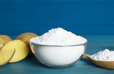 Starch and fresh raw potatoes on light blue wooden table