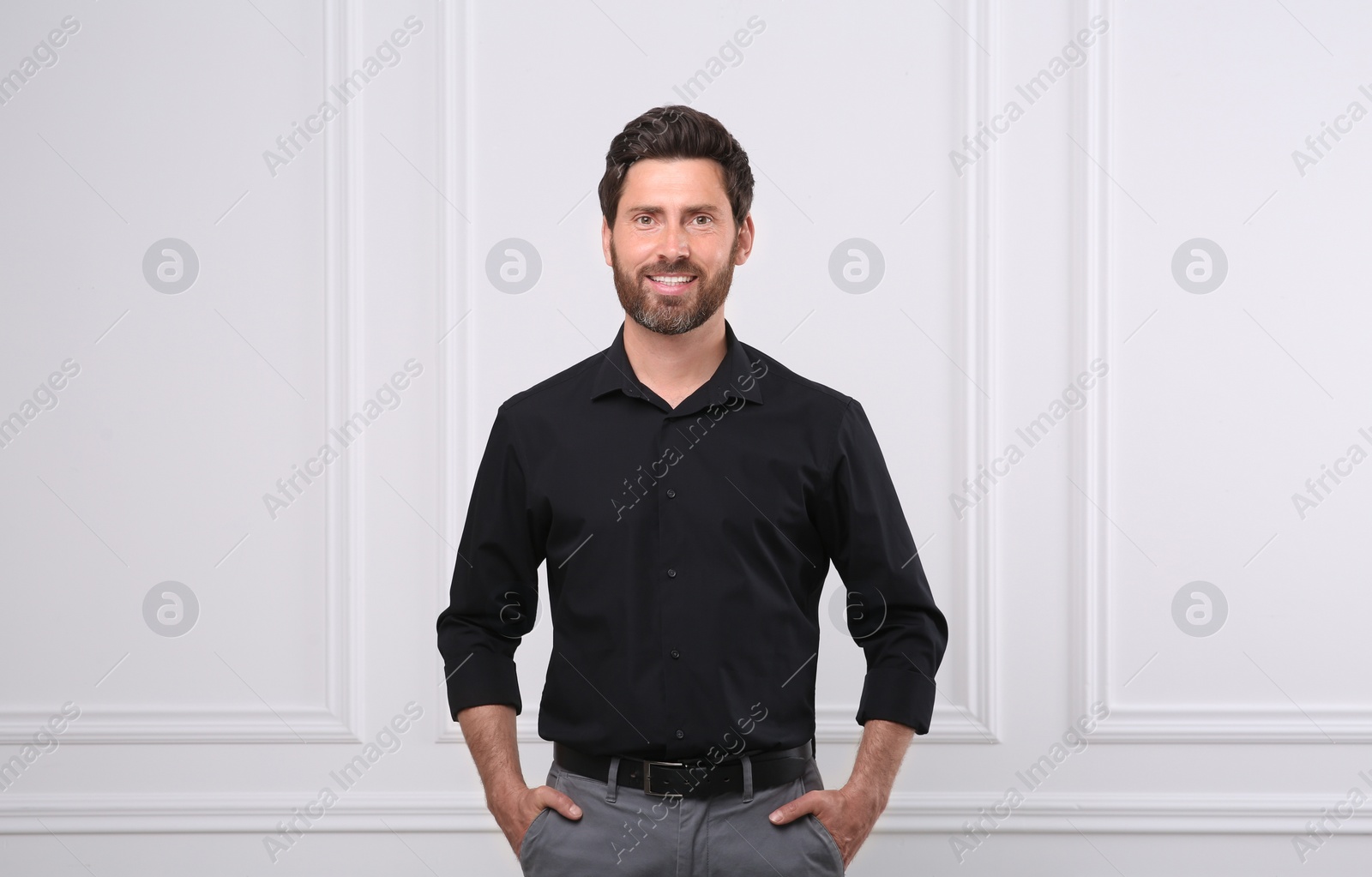 Photo of Portrait of handsome man near white wall