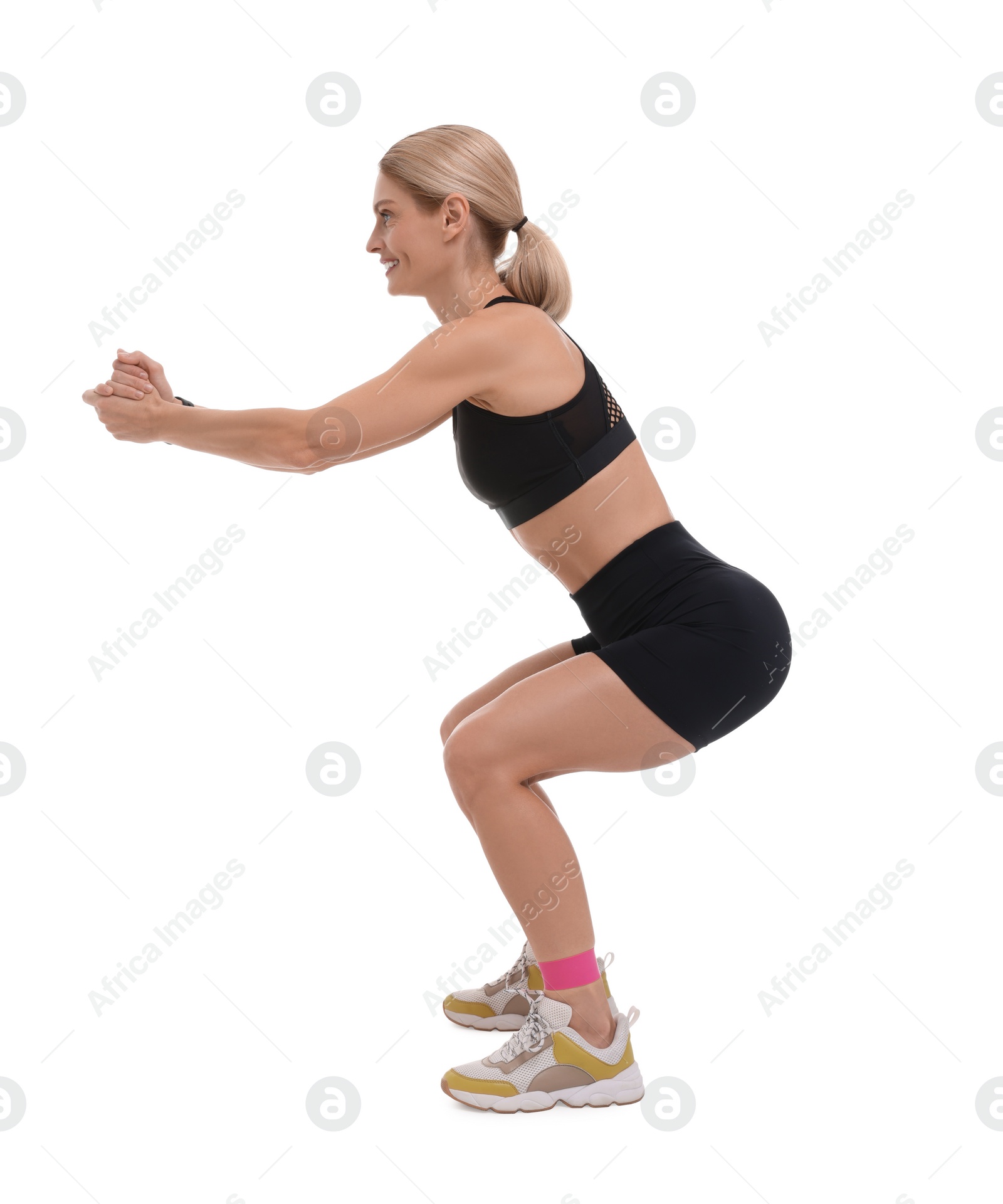 Photo of Woman exercising with elastic resistance band on white background