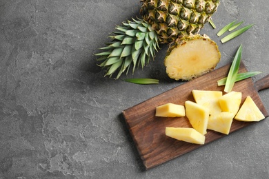 Photo of Wooden board with fresh sliced pineapple on table