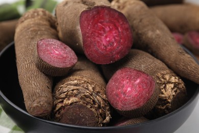 Photo of Whole and cut red beets in bowl, closeup