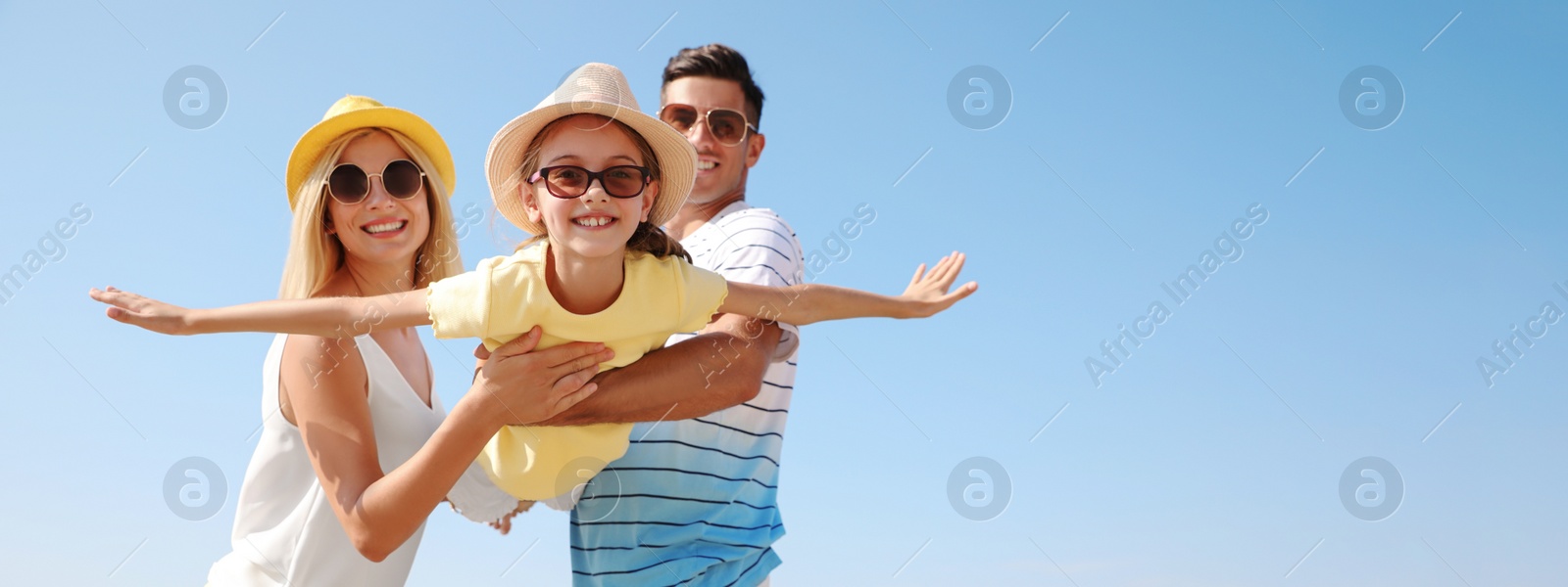 Image of Parents playing with daughter outdoors, space for text. Banner design