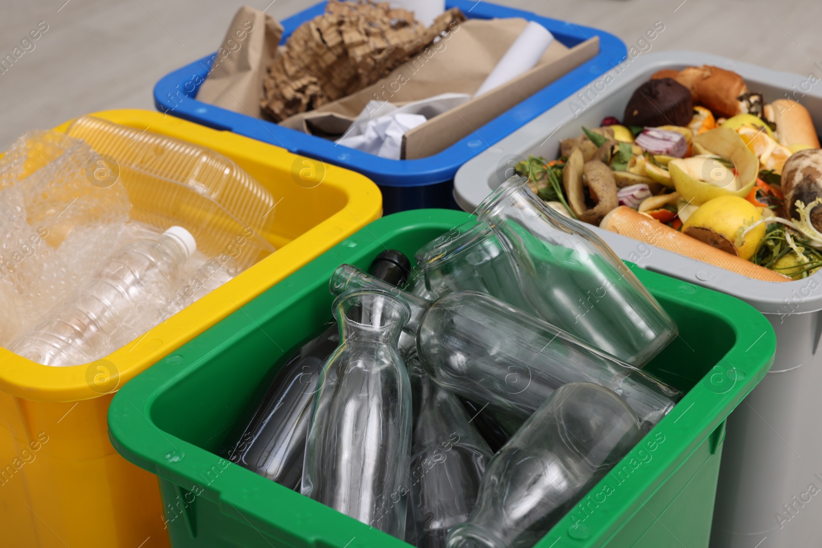 Photo of Garbage sorting. Full trash bins for separate waste collection indoors, closeup