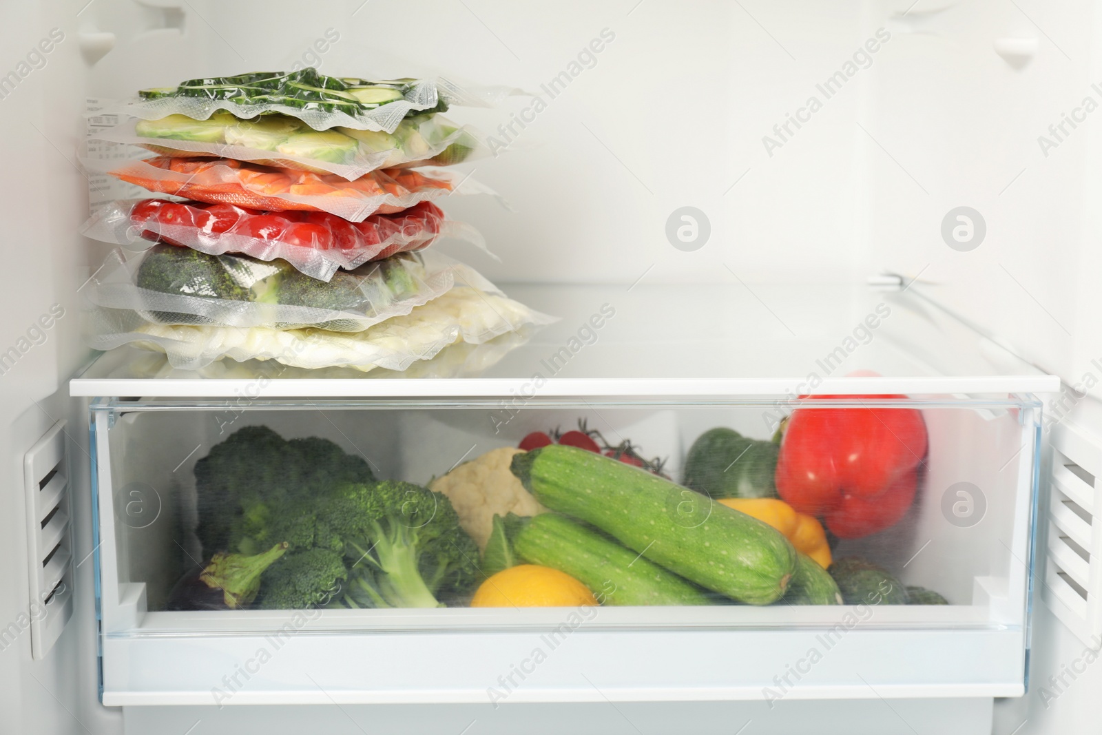 Photo of Vacuum bags with different vegetables in fridge, space for text. Food storage