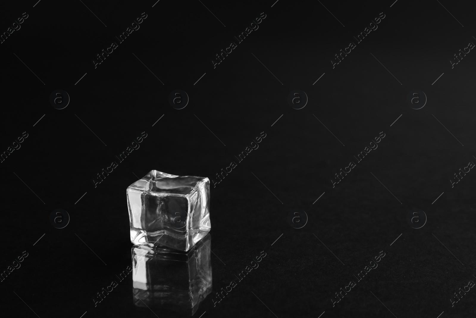 Photo of Crystal clear ice cube on black background. Space for text