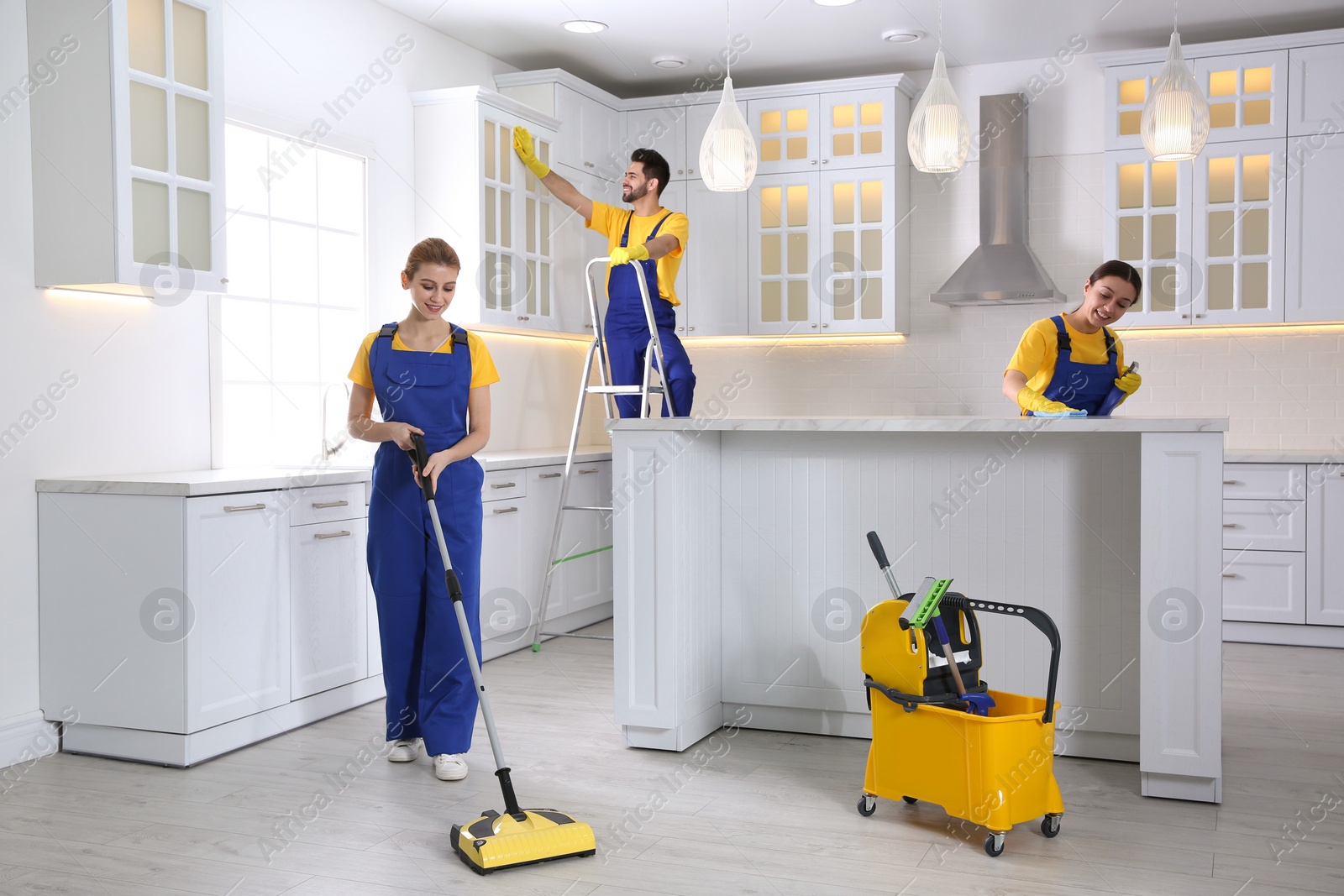 Photo of Team of professional janitors cleaning modern kitchen