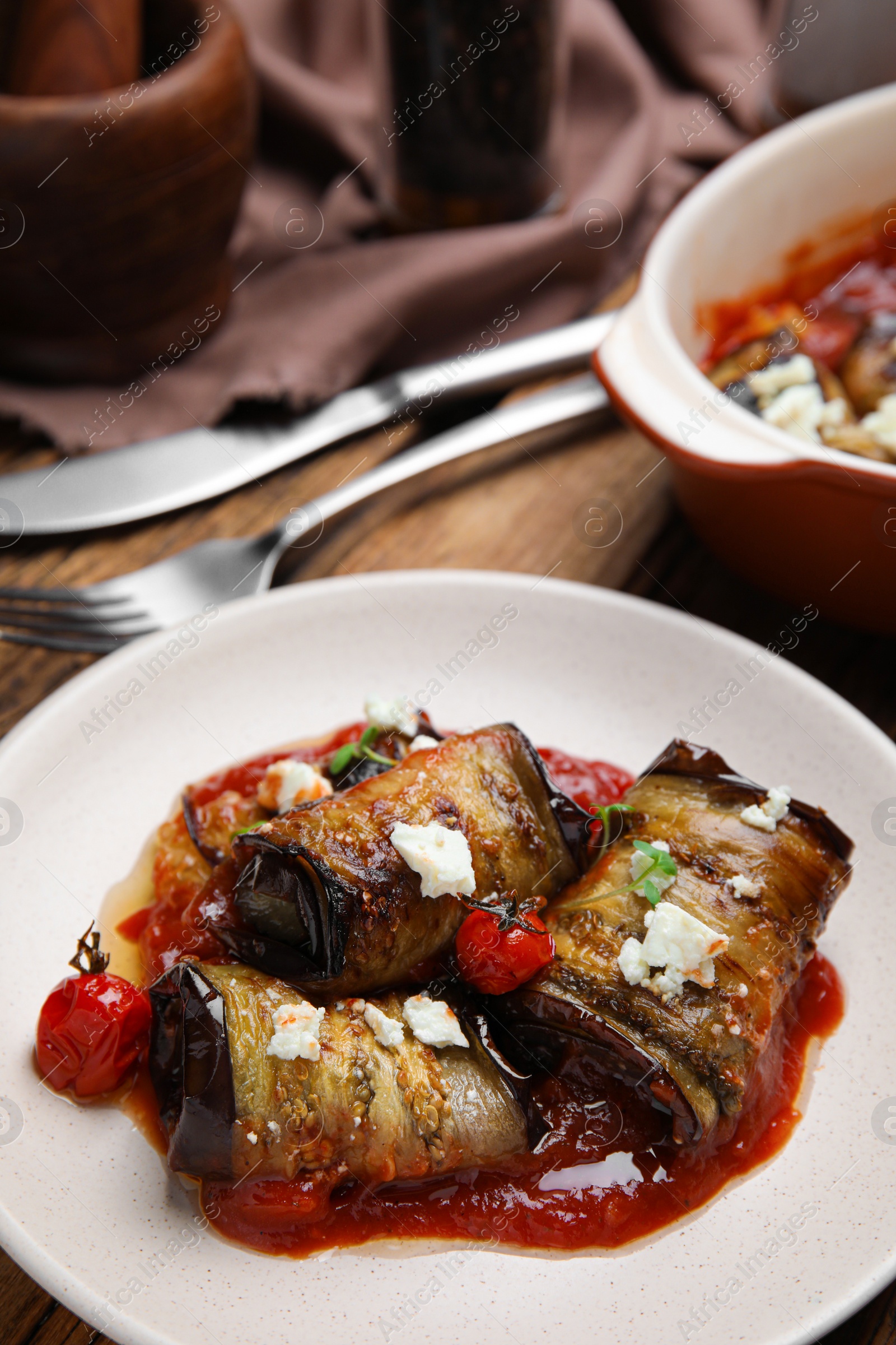 Photo of Tasty eggplant rolls served on table, closeup