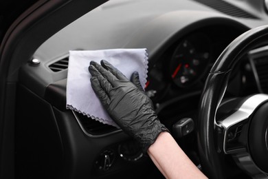 Photo of Woman wiping her modern car with rag, closeup