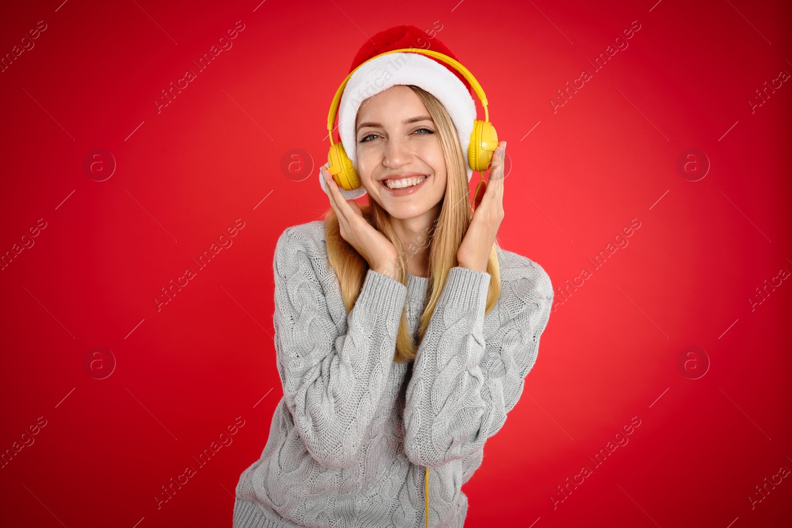 Photo of Happy woman with headphones on red background. Christmas music