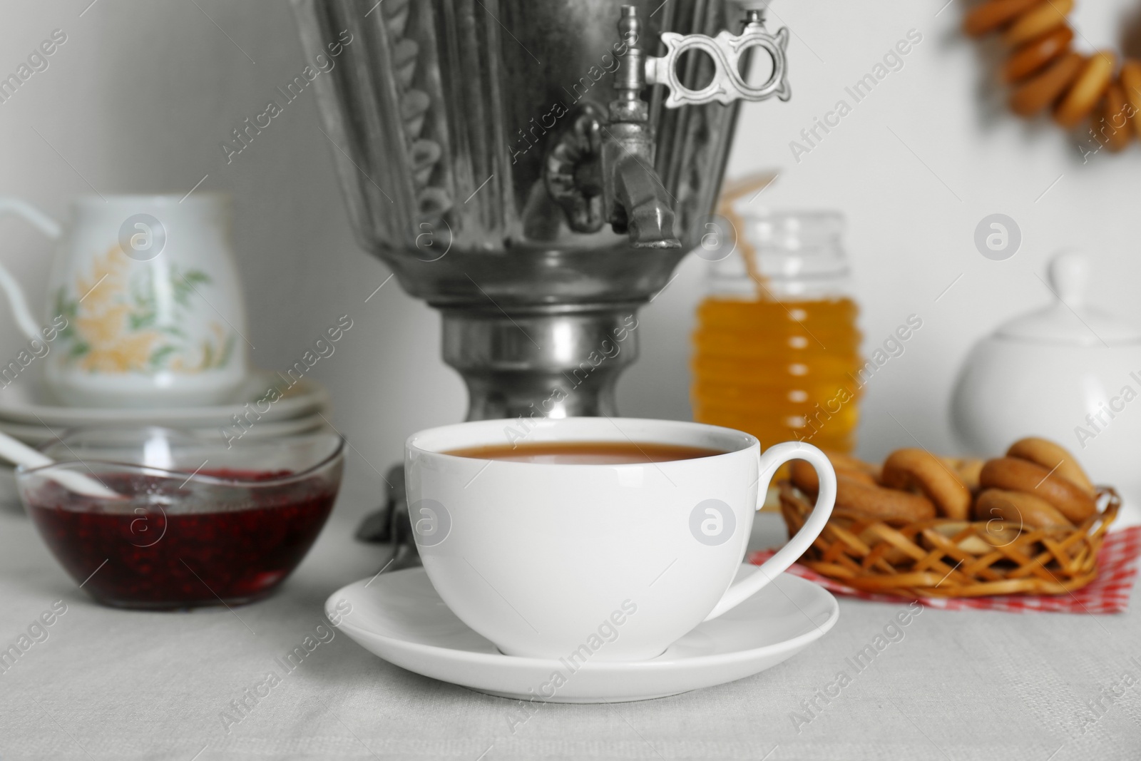 Photo of Composition with delicious ring shaped Sushki (dry bagels) and tea on white table