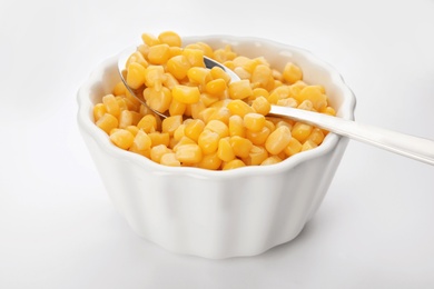 Photo of Bowl and spoon with corn kernels on white background