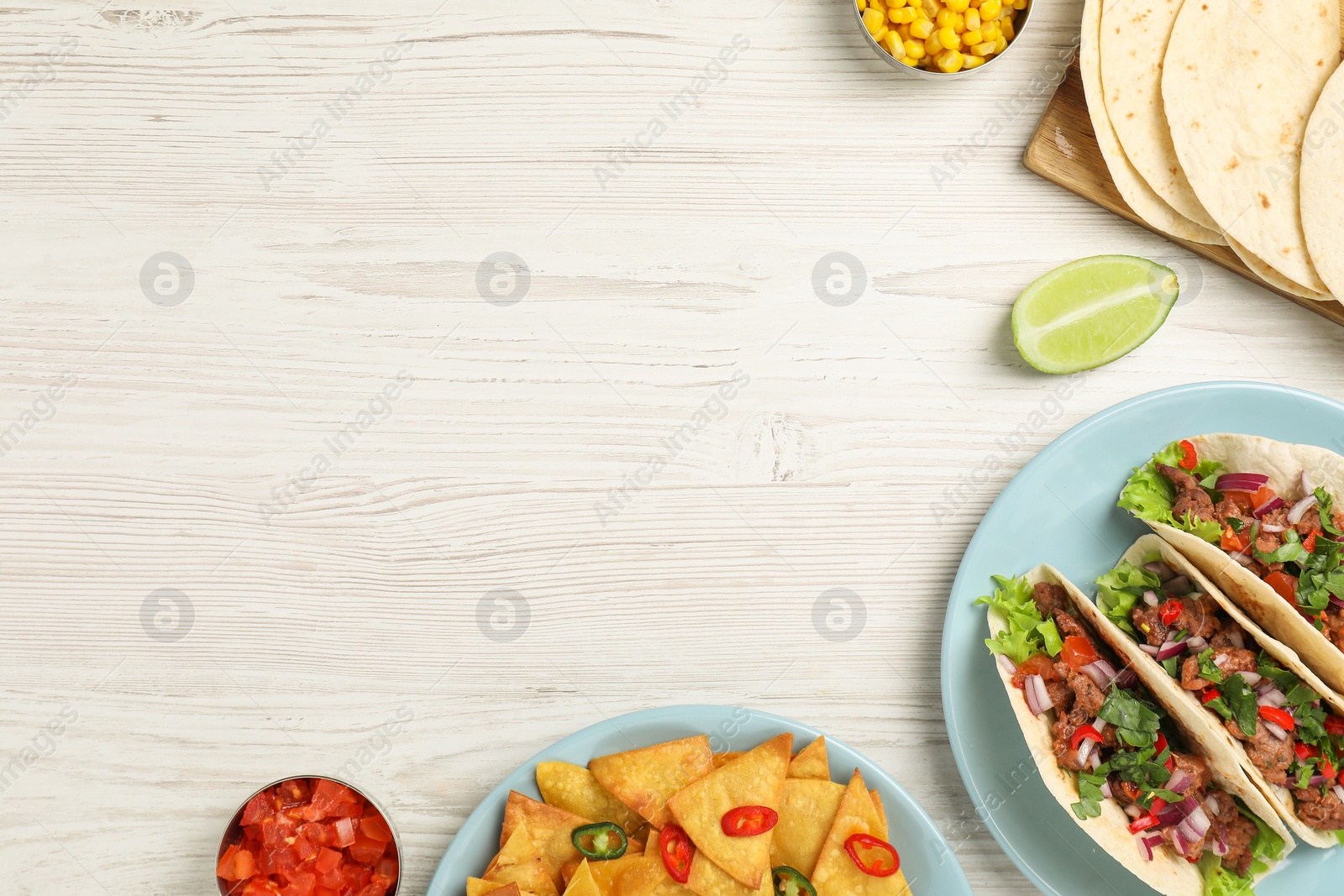 Photo of Flat lay composition with delicious tacos on wooden table, space for text