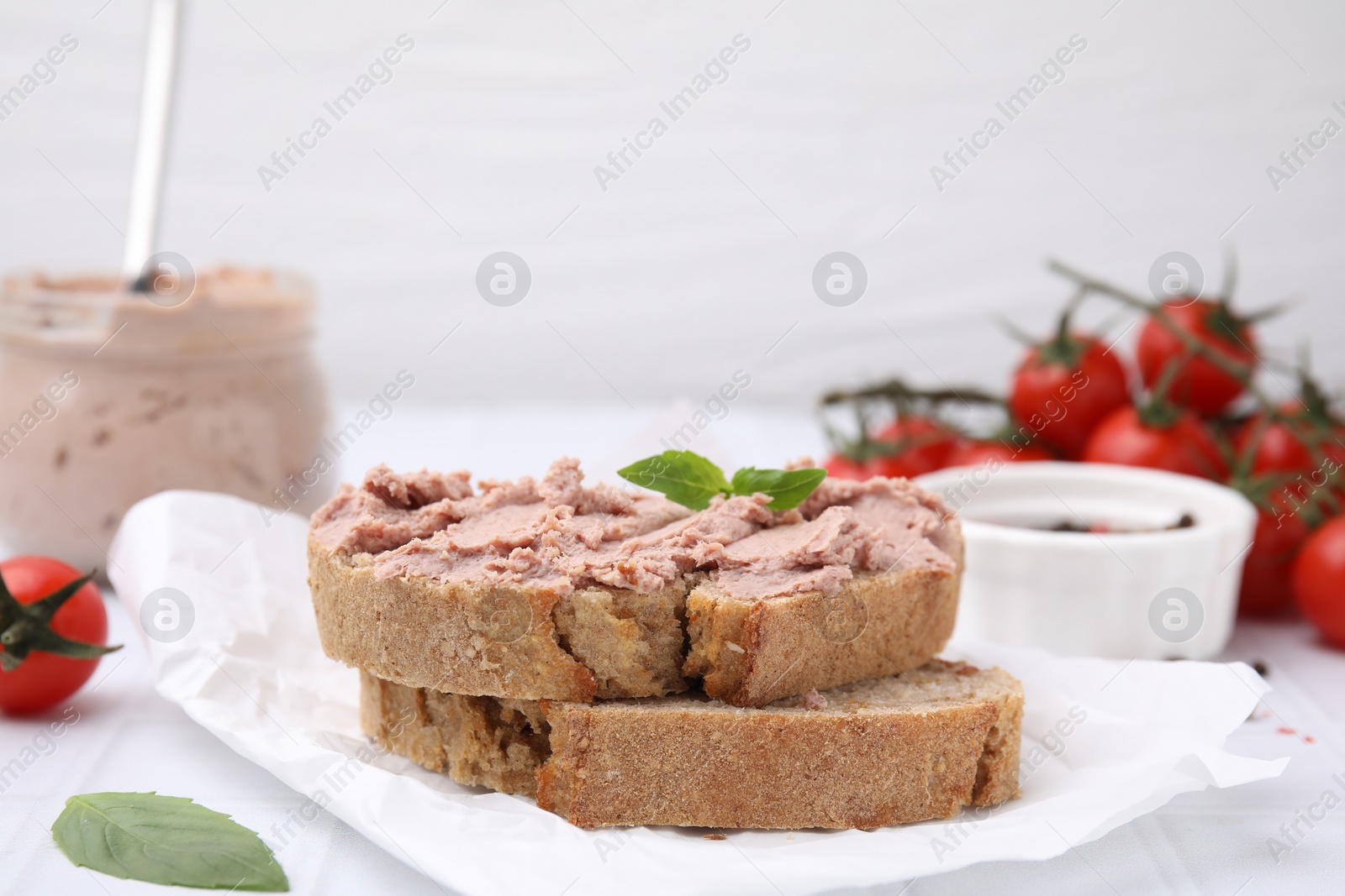 Photo of Delicious liverwurst sandwich with basil on white table