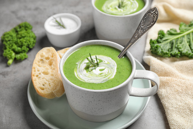 Photo of Tasty kale soup served on grey table, closeup