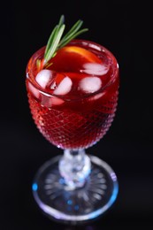 Glass of delicious refreshing sangria on black table, closeup