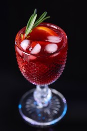 Photo of Glass of delicious refreshing sangria on black table, closeup