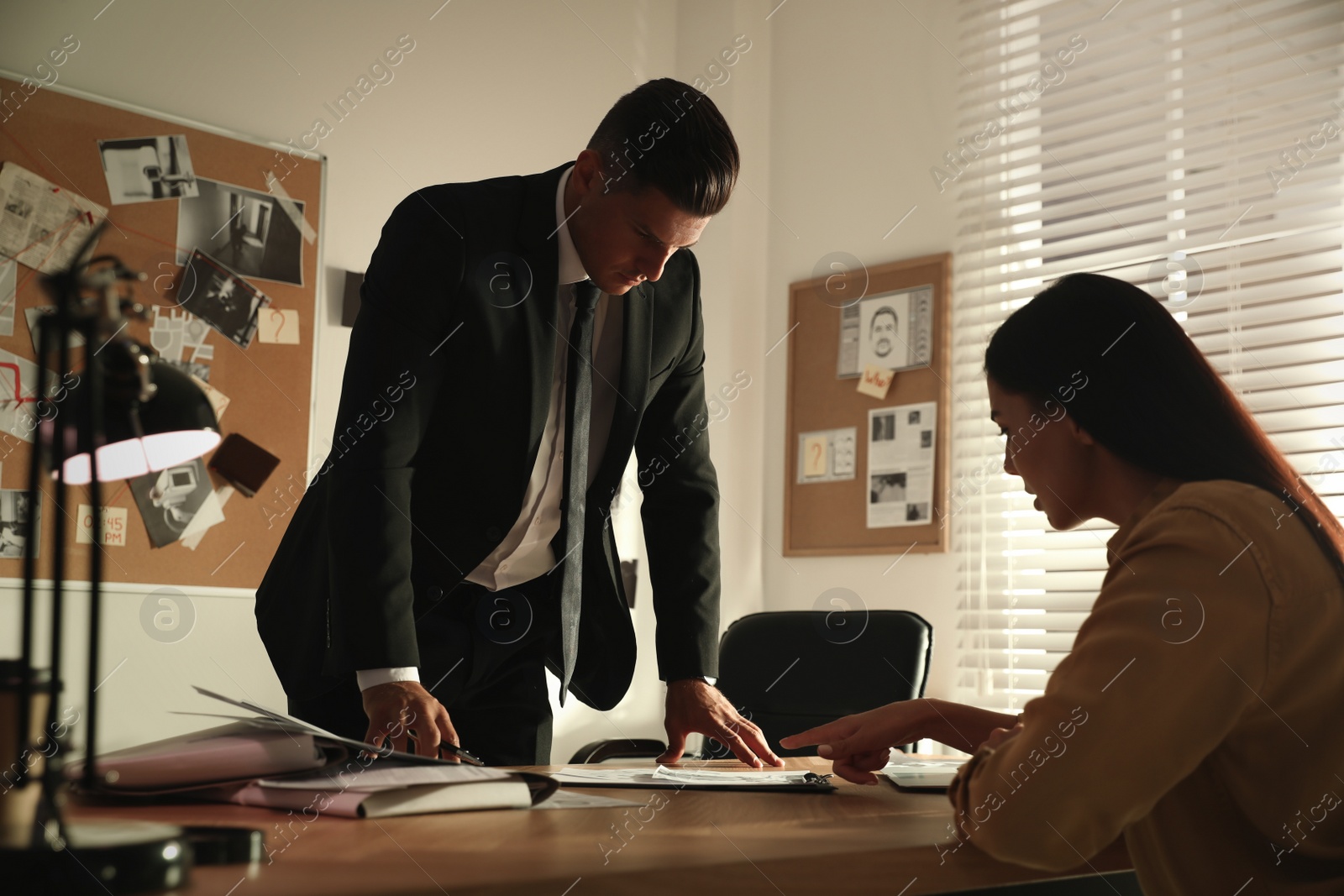 Photo of Detective working with client in his office