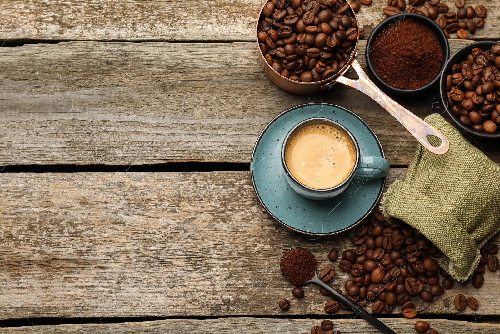 Photo of Coffee beans, powder and cup of drink on wooden table, flat lay. Space for text
