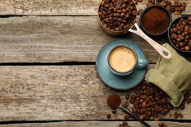 Coffee beans, powder and cup of drink on wooden table, flat lay. Space for text