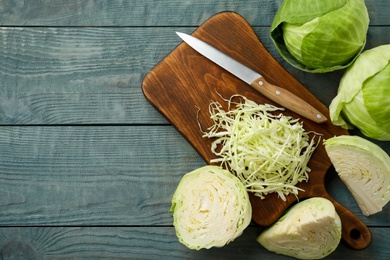 Photo of Chopped cabbage on blue wooden table, flat lay. Space for text