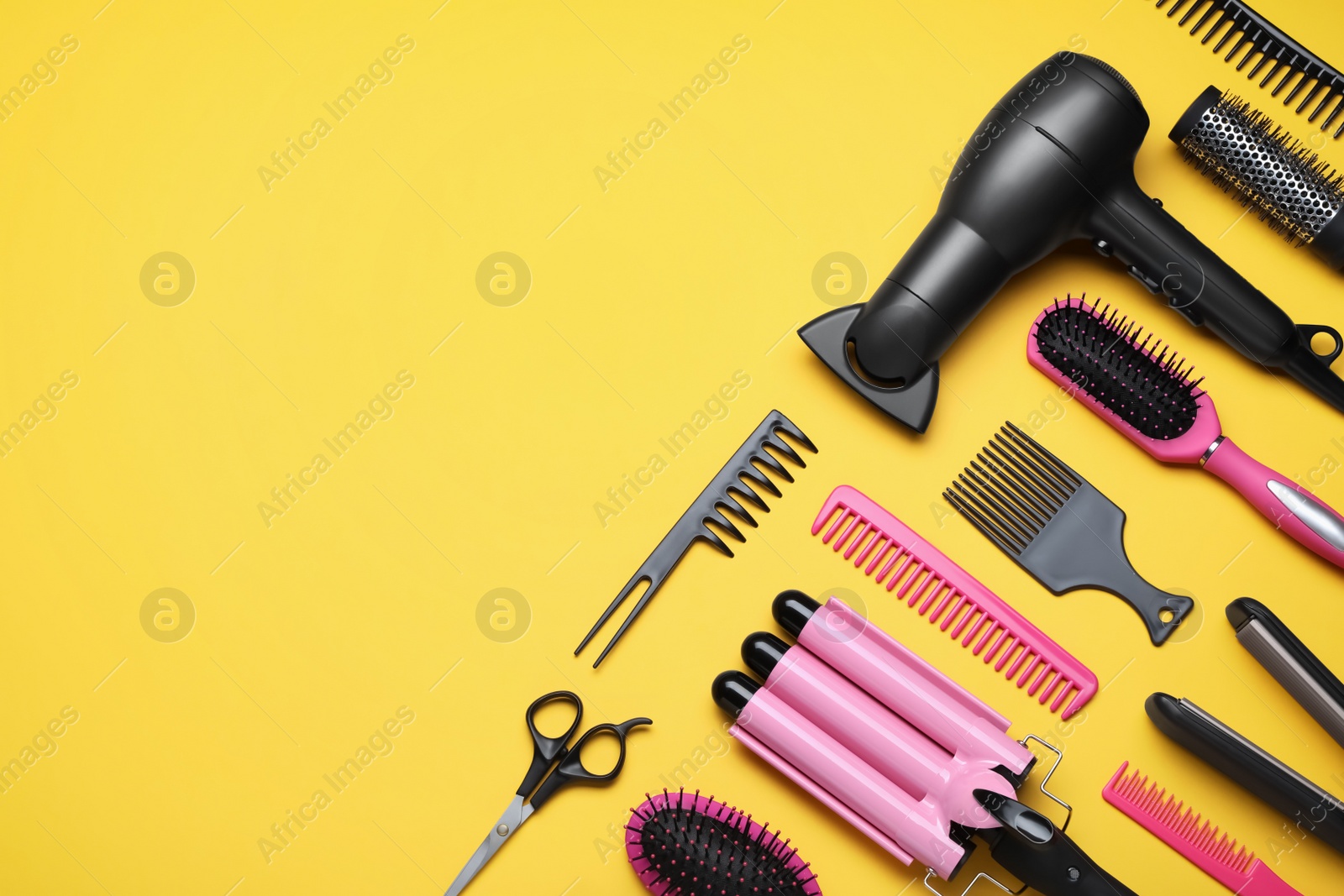 Photo of Flat lay composition of professional hairdresser tools on orange background, space for text